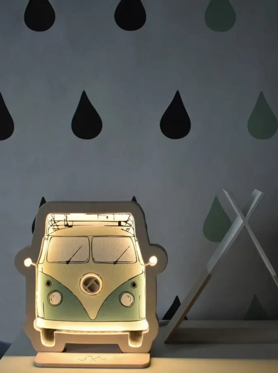 Drewniana lampka dekoracyjna w kształcie retro busa, świecąca ciepłym światłem LED, umieszczona na ścianie w pokoju dziecięcym.