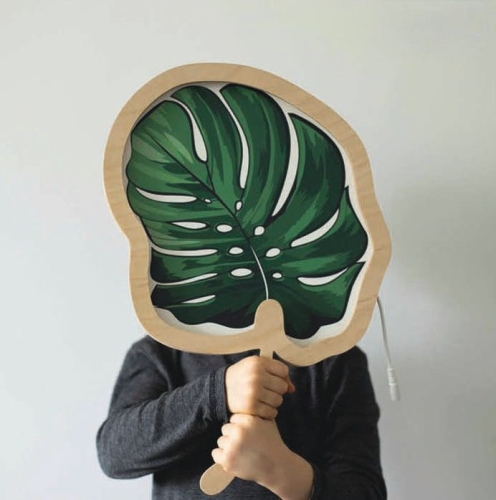 Drewniana lampka LED w kształcie liścia Monstera, świecąca ciepłym światłem, idealna do dekoracji wnętrza w stylu naturalnym.