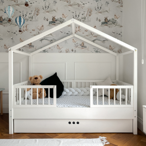 Łóżko domek Dream Nest Snow z białego drewna, w stylu Montessori, z barierkami ochronnymi i regulowanym poziomem leżyska, idealne dla dzieci w wieku od 18 miesięcy.