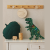Personalizowana tabliczka z grawerem dinozaura, wykonana ze sklejki brzozowej, z imieniem dziecka i ulubionym wzorem dinozaura.