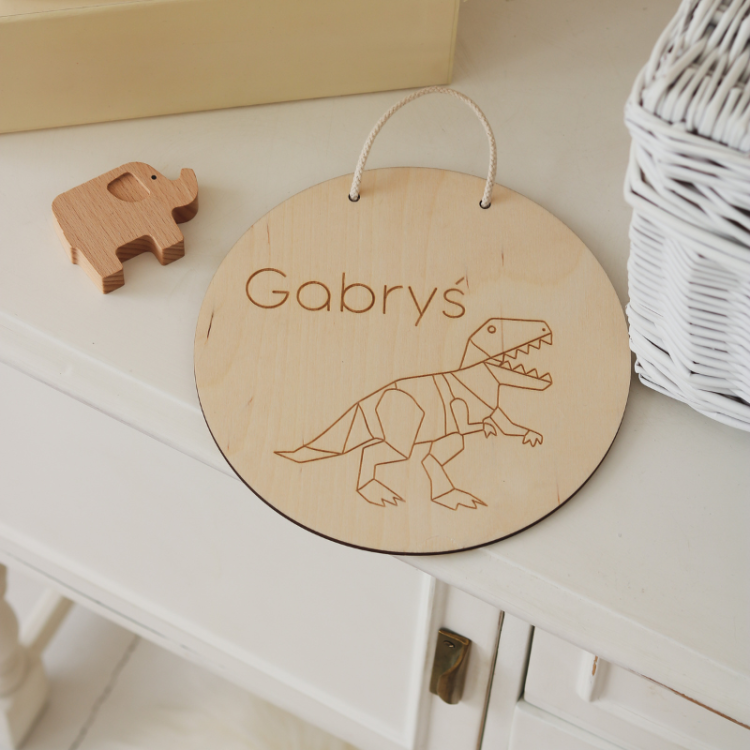 Personalizowana tabliczka z grawerem dinozaura, wykonana ze sklejki brzozowej, z imieniem dziecka i ulubionym wzorem dinozaura.