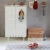 Biała wysoka komoda Babushka w stylu retro, z pięcioma szufladami i szafką z półkami. Funkcjonalna i stylowa komoda dziecięca od Wood Luck Design