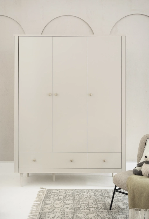 szafa 3-drzwiowa dziecięca Pinio Petite w kolorze szampańskim, styl art déco, z uchwytami w kolorze zgaszonego złota i drewnianymi nóżkami