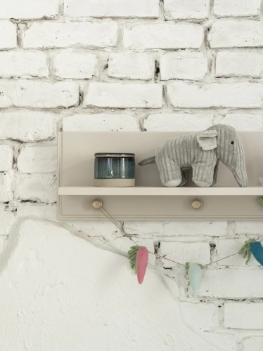 półka wisząca dziecięca Pinio Petite, szampańska, z ramką zabezpieczającą, styl art déco, zawieszona nad komodą