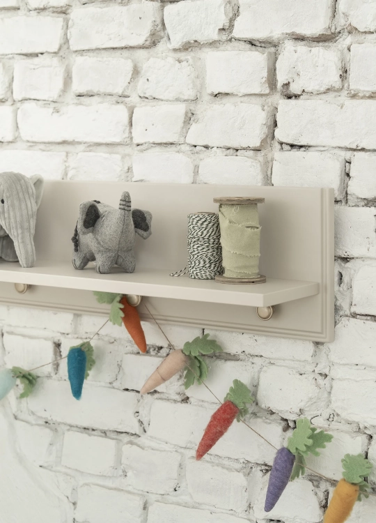 półka wisząca dziecięca Pinio Petite, szampańska, z ramką zabezpieczającą, styl art déco, zawieszona nad komodą