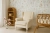 fotel Lugo kremowy velvet w salonie, fotel uszak velvet kremowy z podnóżkiem, fotel do karmienia w stylu klasycznym, elegancki fotel aksamitny kremowy, fotel Lugo kremowy na drewnianych nogach