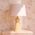 elegancka lampa Bushka Powder w stylu vintage na komodzie w pastelowym pokoju dziecka