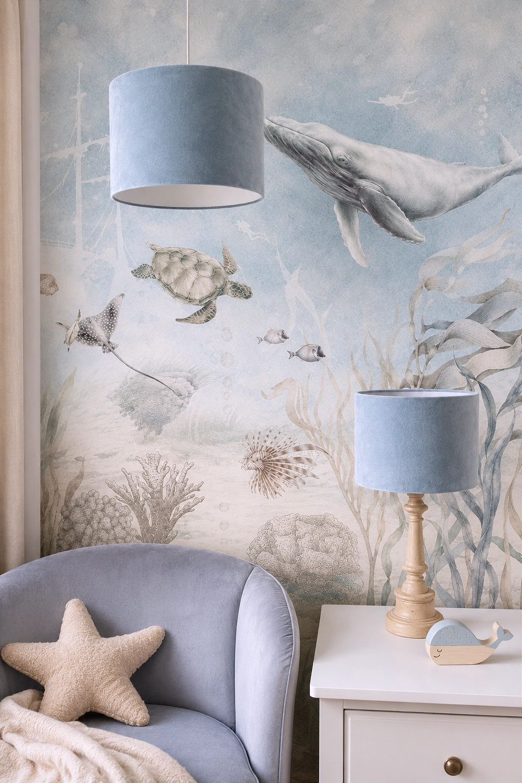 Lampa wisząca i drewniana lampa stojąca Velvet Blue w aranżacji z tapetą Marine Adventure, błękitnym fotelem i beżową poduszką